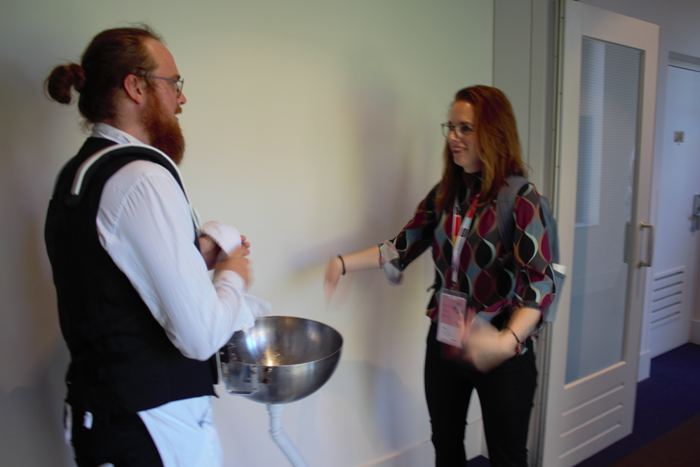 Two festival attendees talk in a hallway between sessions.